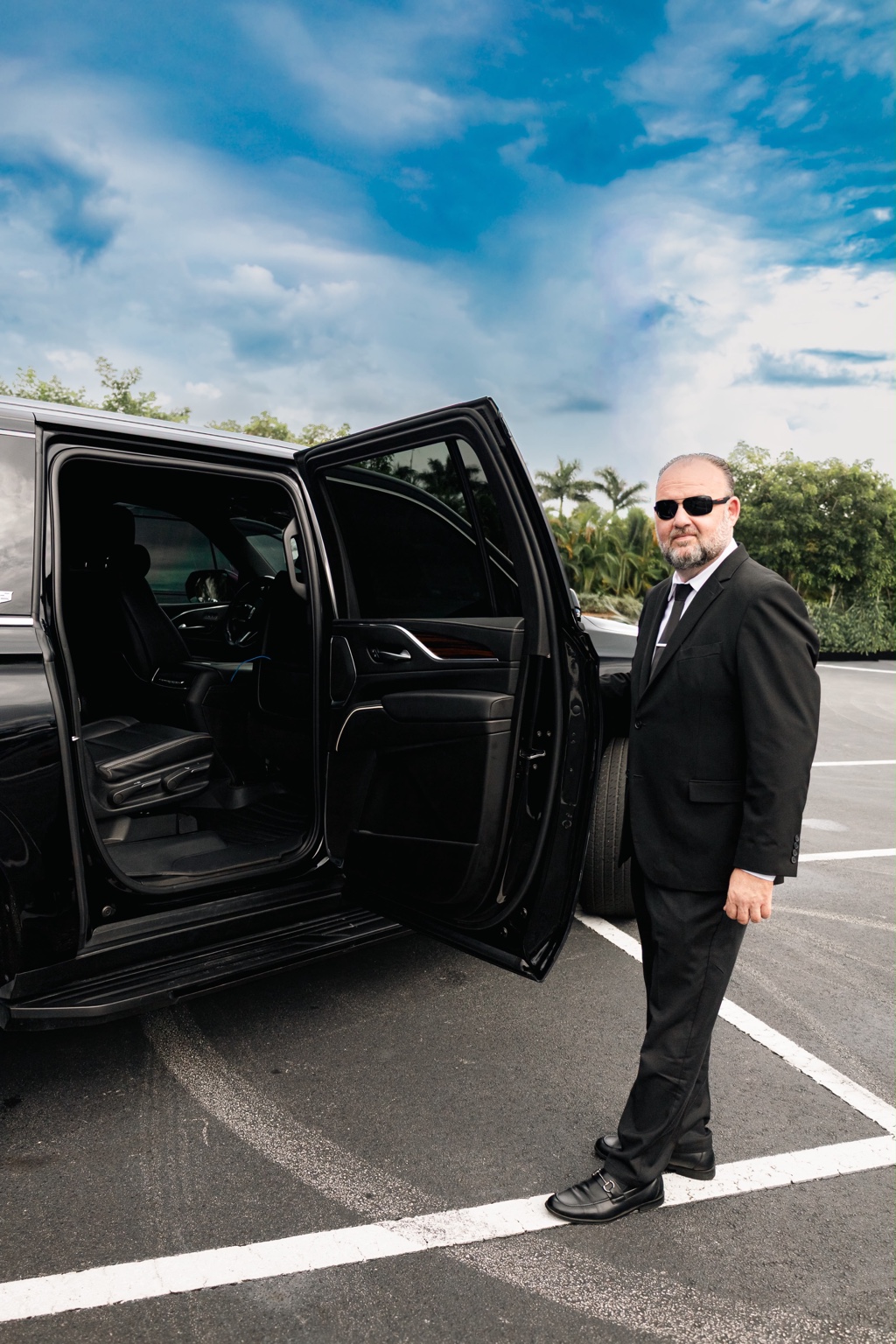 Chauffeur holding the Cadillac Escalade passenger door open